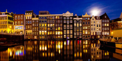 Die typischen Grachtenhäuser von Amsterdam bei Nacht © Ditty_about_summer/ Shutterstock.com