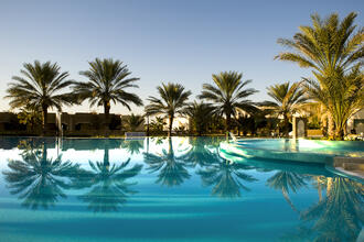Palmen an einem luxoriösen Pool in Djerba © parkisland / Shutterstock.com